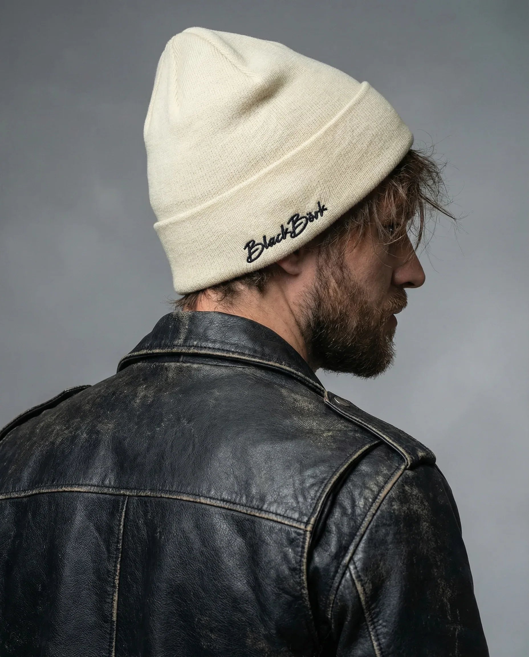 back_of_the_hat_front_of_the_hat_._create_a_model_shot_with_soft_and_gray_background_that_hat_logo_is_located_on_the_back_of_the_hat_and_on_the_right_side_of_the_hat_.logo_should_be_l - BlackBork